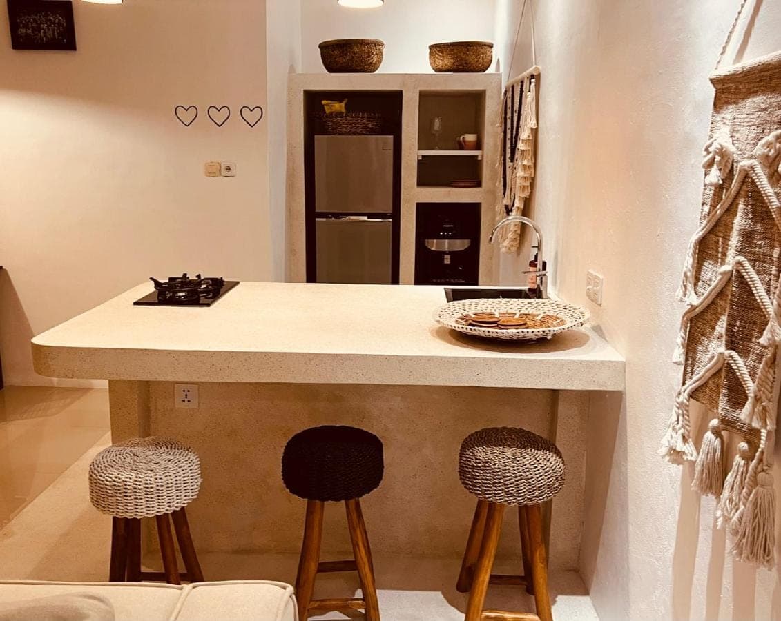 a kitchen with two bar stools and a counter top at Love Song Villa Canggu in Canggu