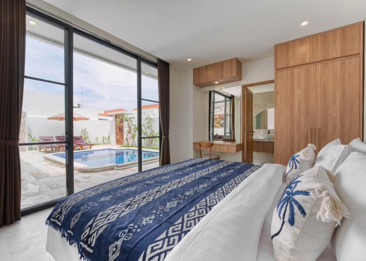 a bedroom with a bed and a view of a pool at Narayuka private villa Seminyak in Seminyak