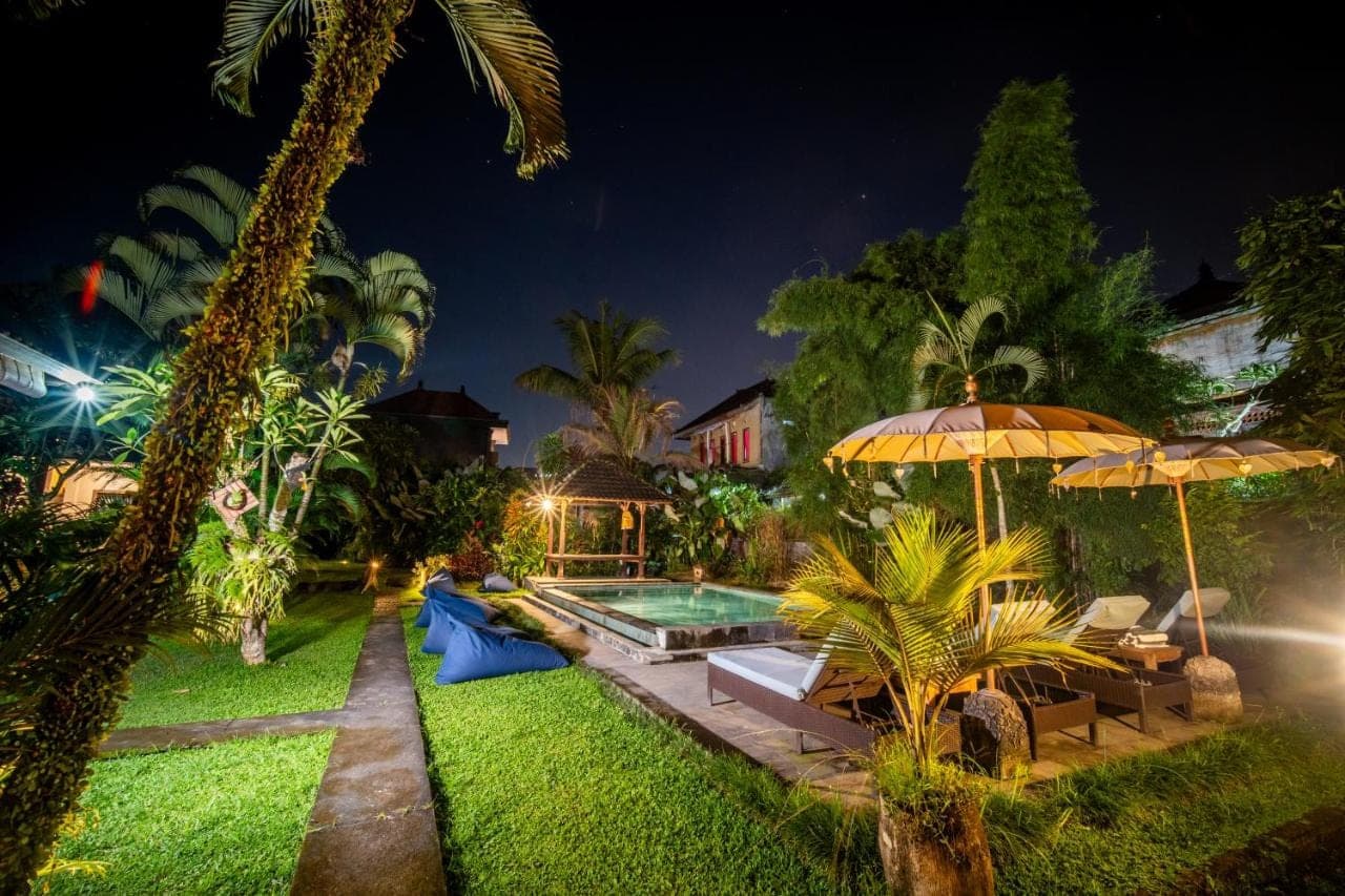 a backyard with a pool and an umbrella at Alit Bungalow Ubud in Ubud