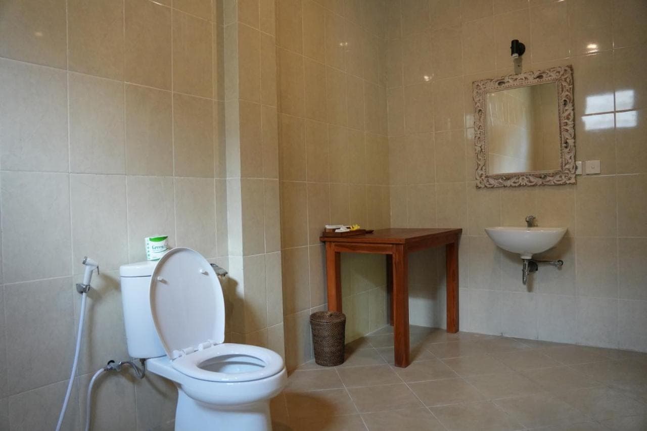 a bathroom with a toilet and a sink at Alit Bungalow Ubud in Ubud