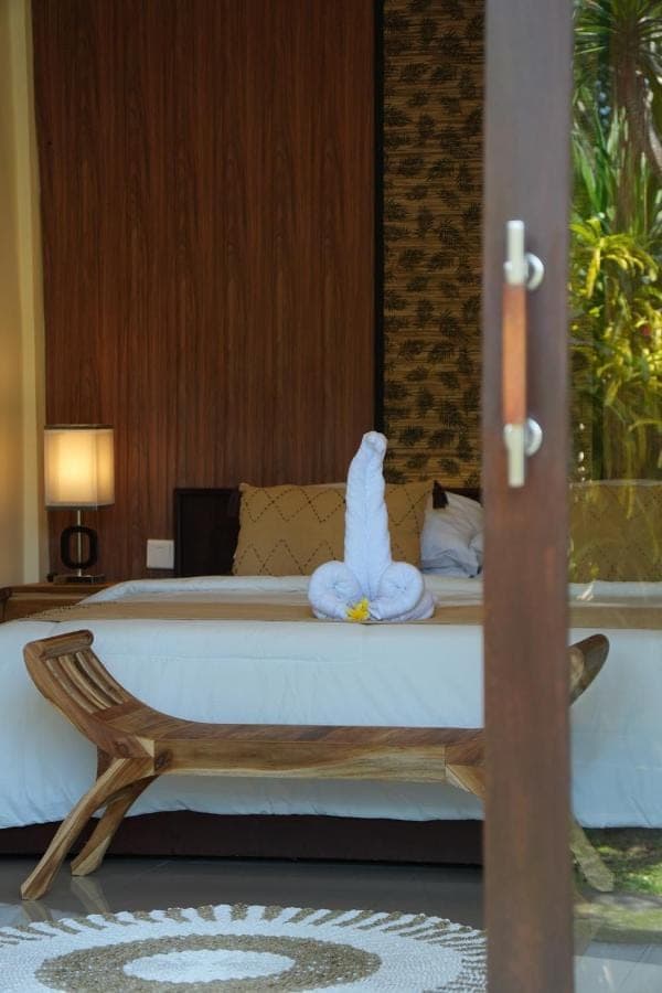 a bed with a towel animal sitting on top of it at Alit Bungalow Ubud in Ubud