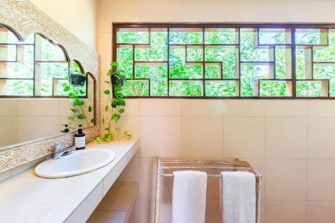a bathroom with a sink and a window at Indahwatu in Uluwatu