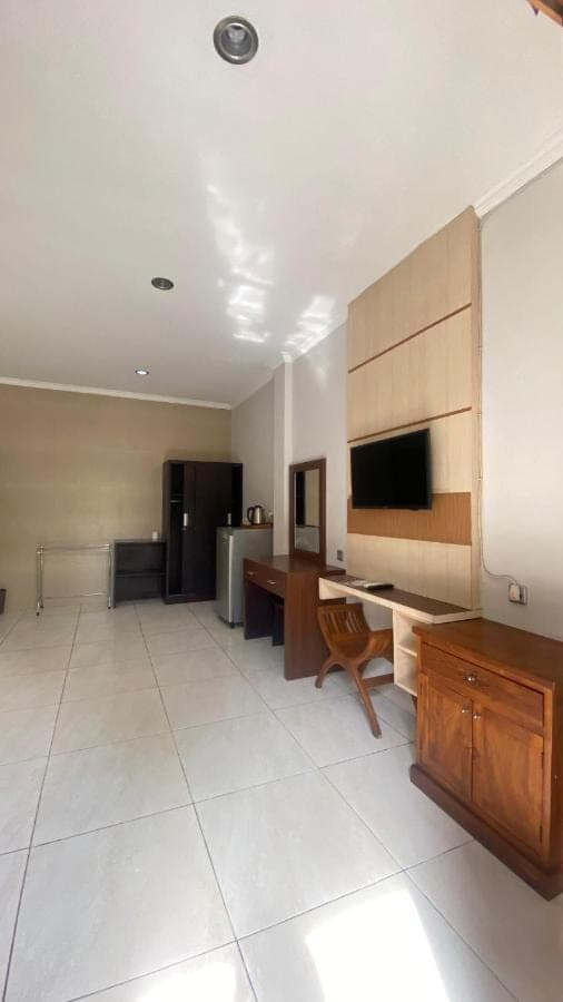 a large room with a desk and a television at Surya Inn in Kuta