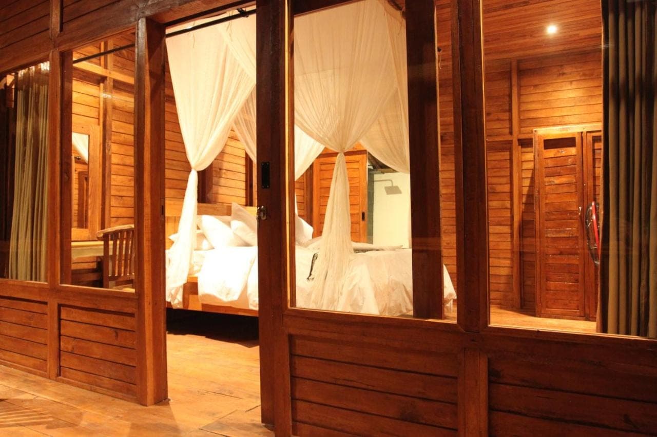 a room with a bedroom with a bed in it at Manuk Dewata Villa in Sidemen