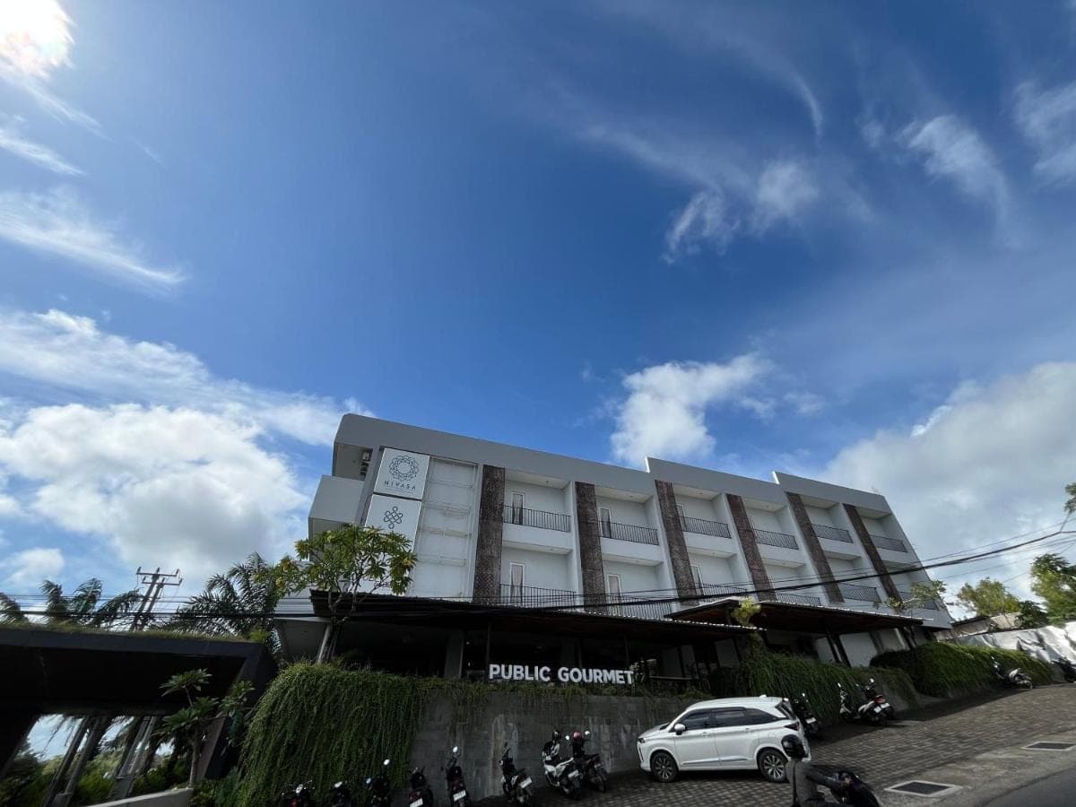 a white car parked in front of a building at Nivasa Hotel in Nusa Dua
