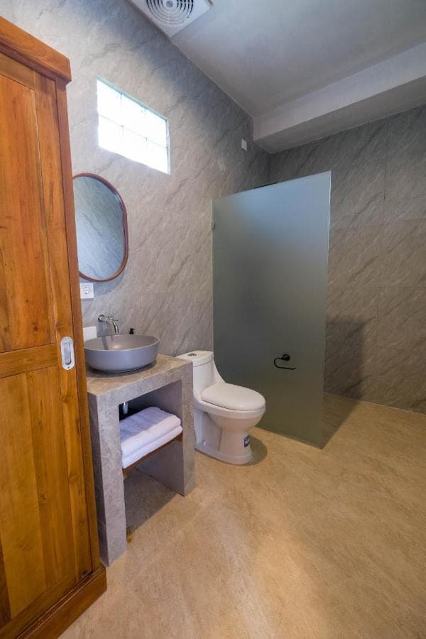 a bathroom with a toilet and a sink and a mirror at Askay Homestay Uluwatu in Uluwatu
