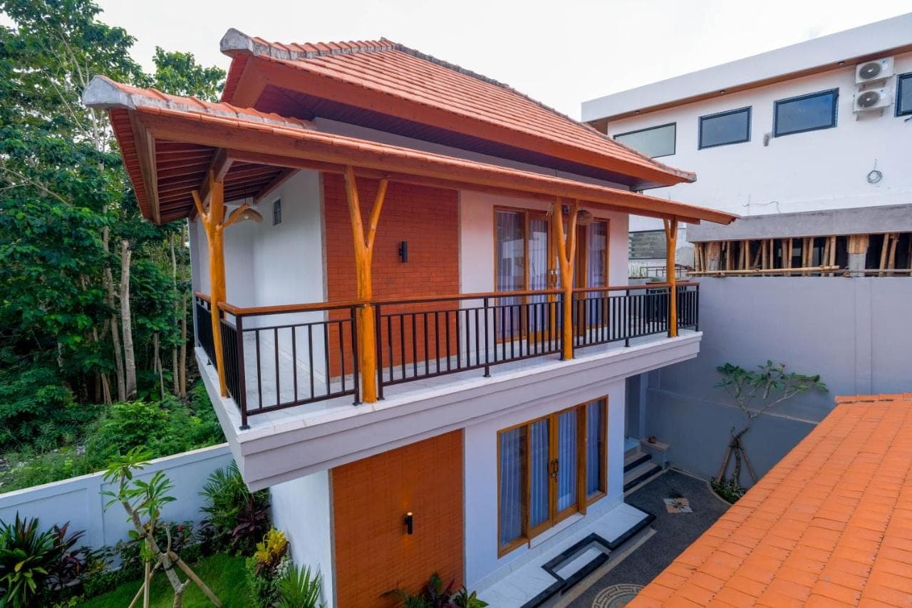 a house with a balcony with a roof at Askay Homestay Uluwatu in Uluwatu