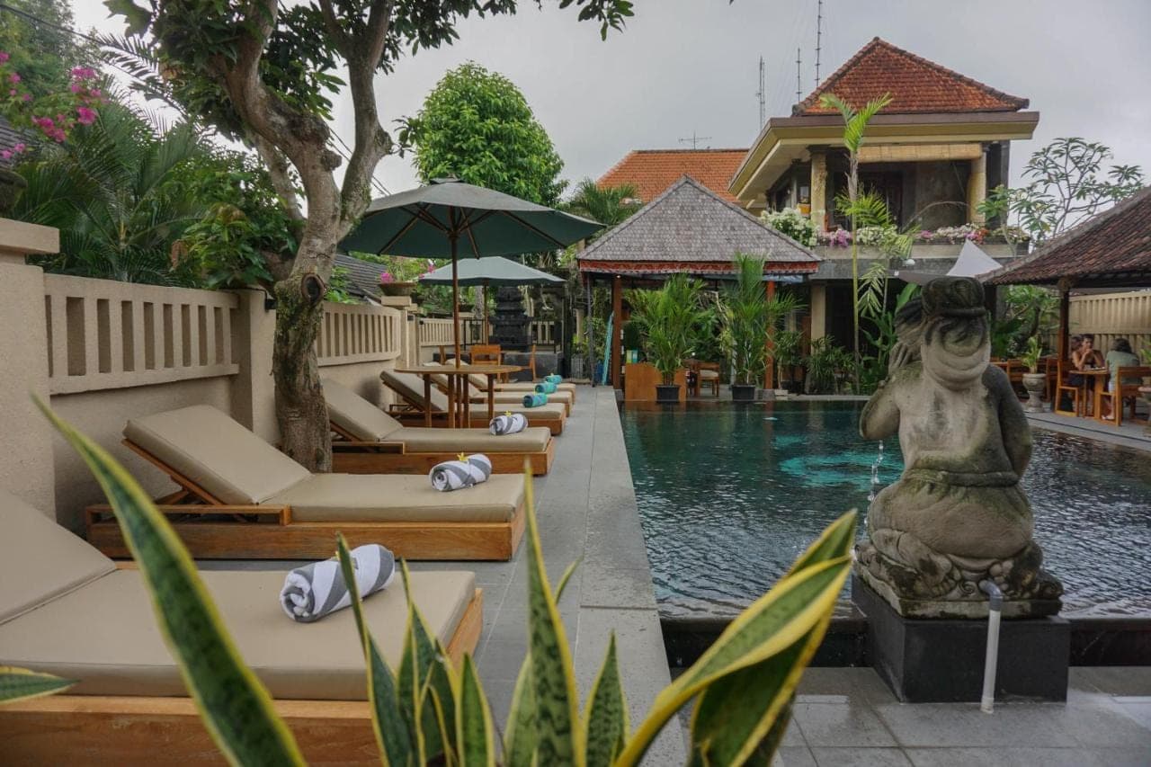 a pool with a statue of a mermaid next to a building at Ubud Aura Wellness Sanctuary in Ubud