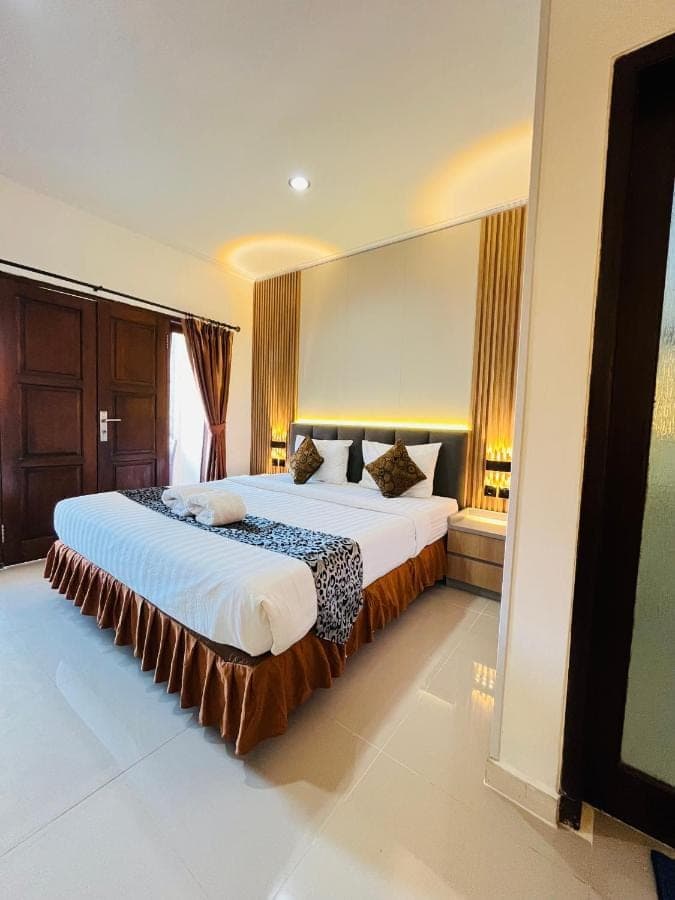 a bedroom with a large bed in a room at Jesens Inn II in Kuta