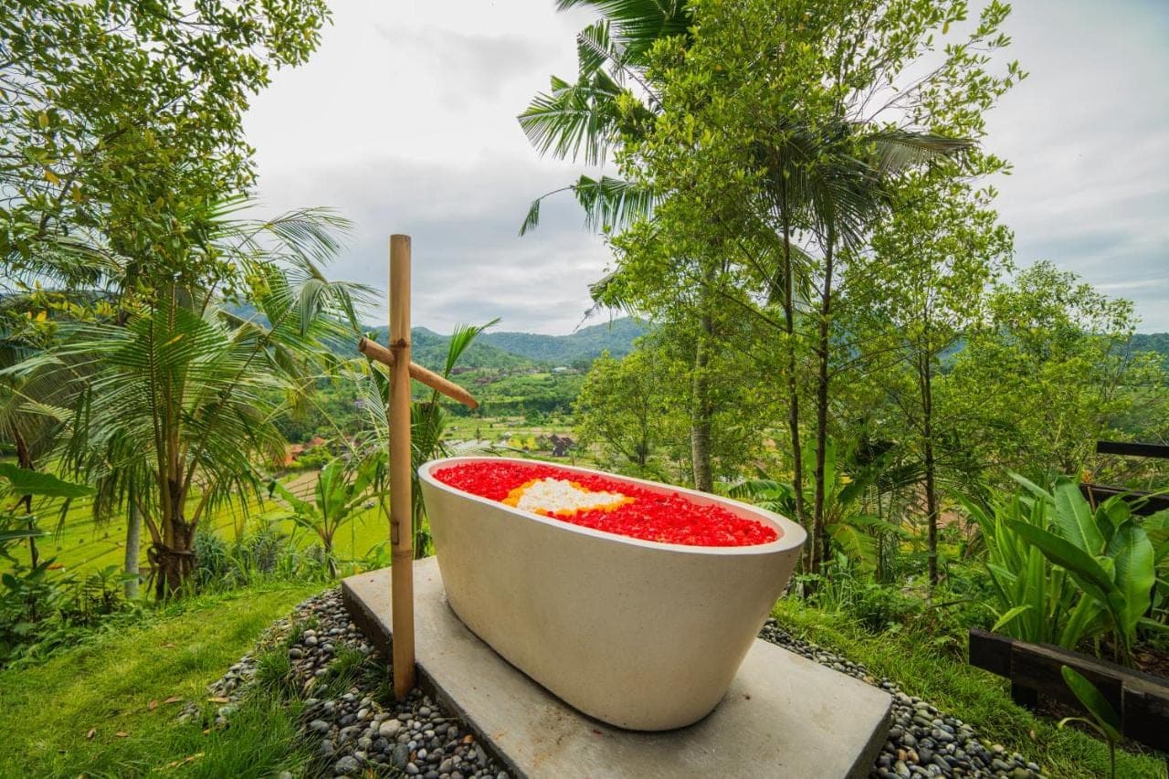 a bath tub filled with red liquid sitting on a ledge at LeLangit Eco Cabin in Sidemen