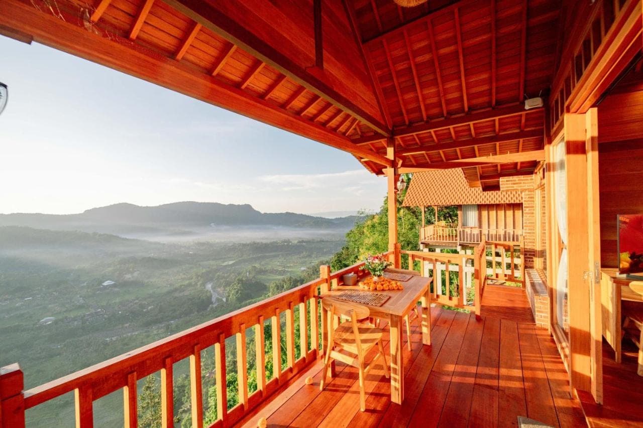 a balcony of a house with a table and a view at Pitak Hill Villa Sidemen in Sidemen