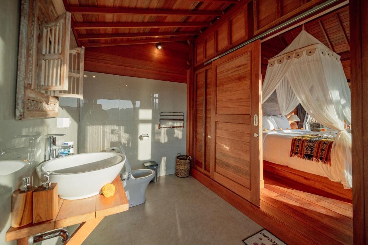 a bathroom with a tub and a bedroom with a bed at Pitak Hill Villa Sidemen in Sidemen