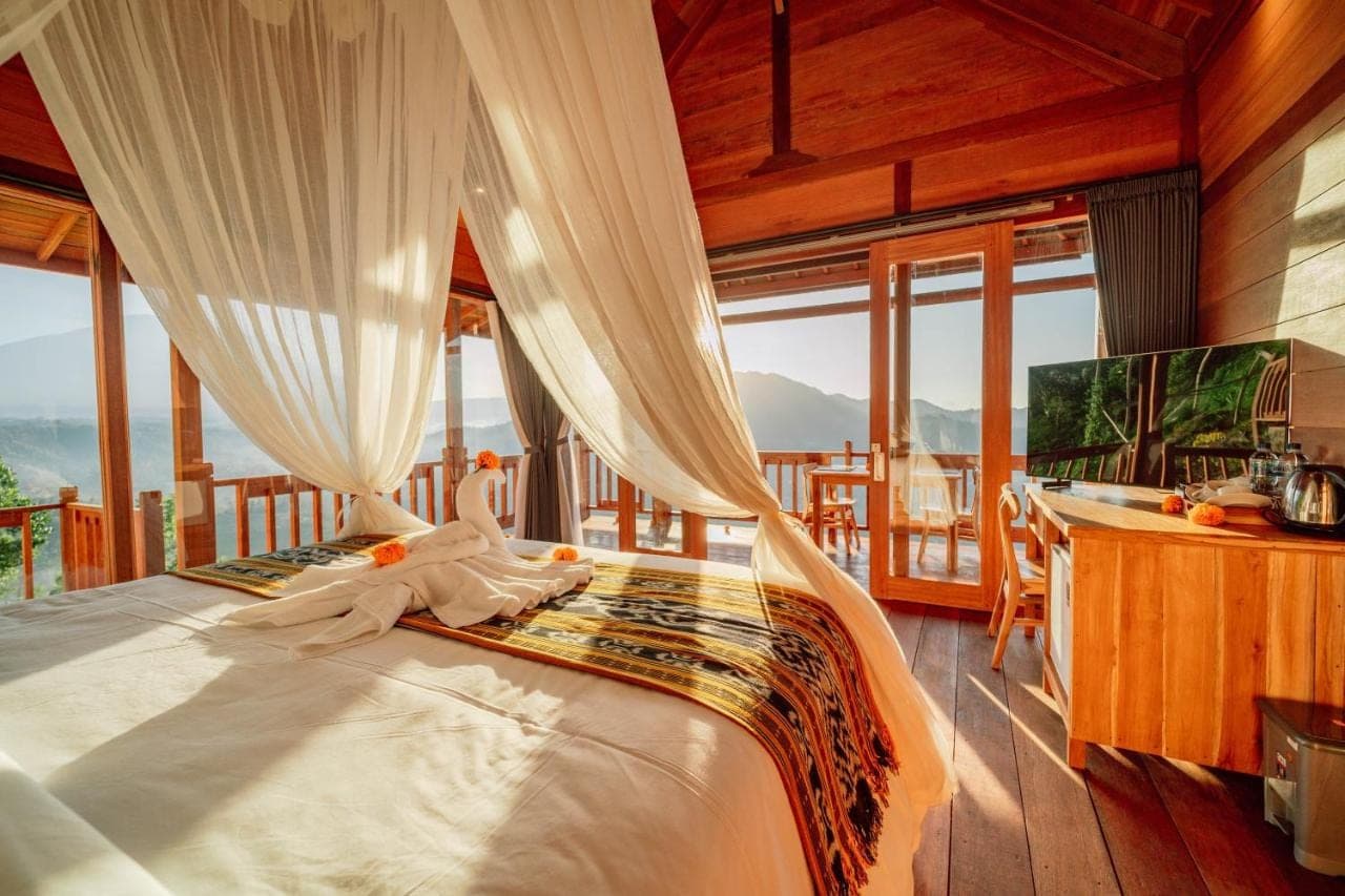 a bedroom with a bed in a room with windows at Pitak Hill Villa Sidemen in Sidemen