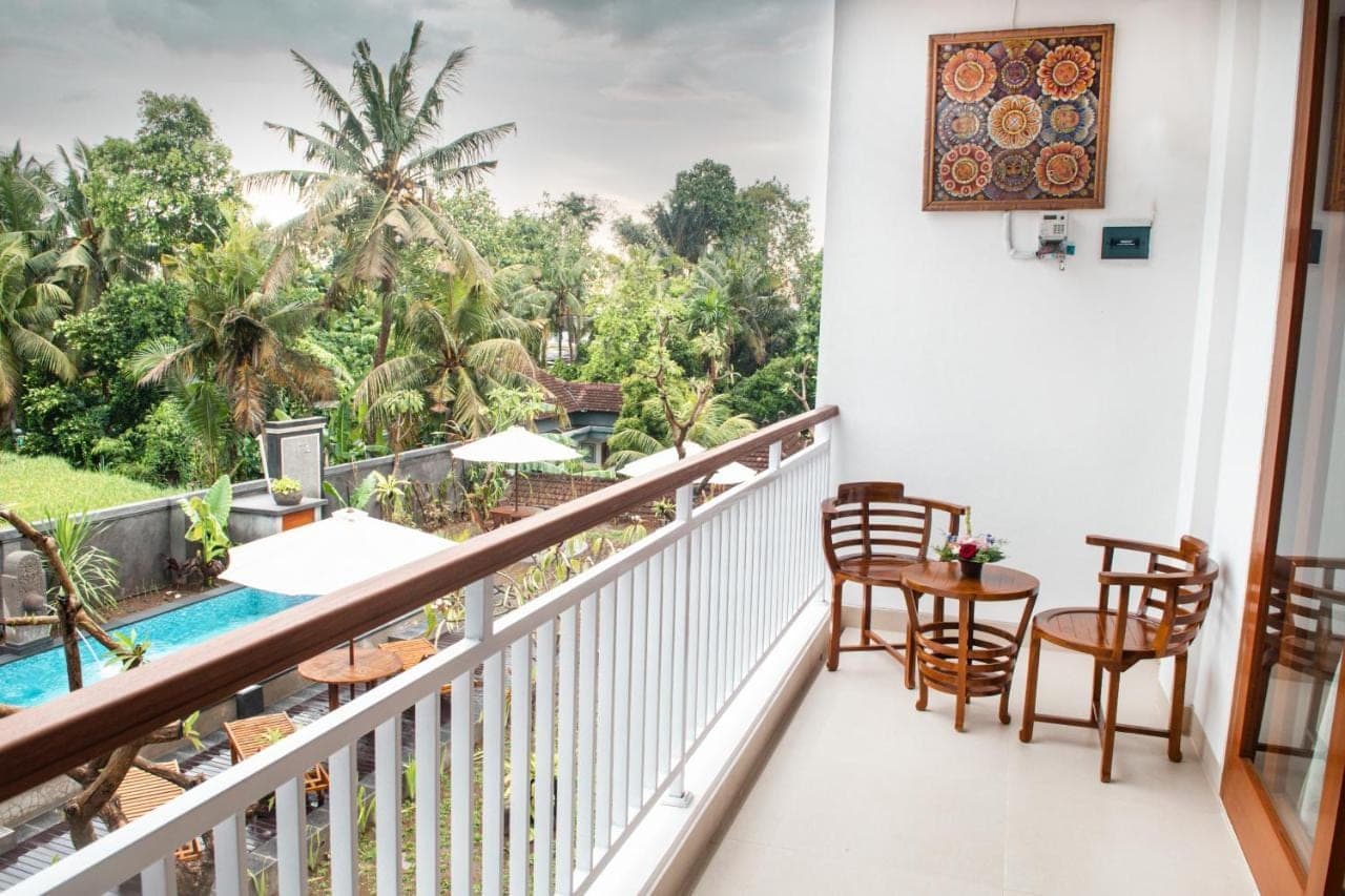 a balcony with a table and chairs and a pool at Siboghana retreat in Ubud