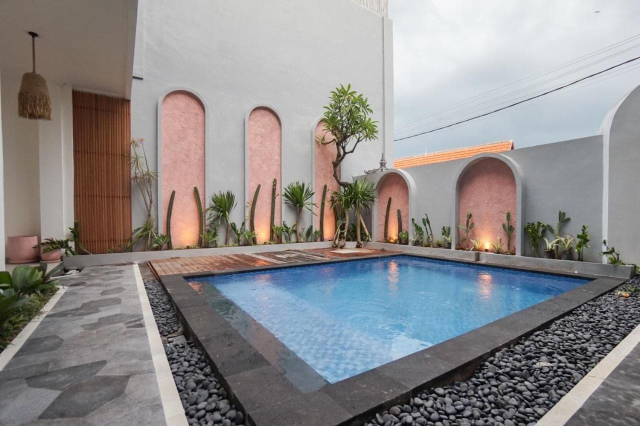 an indoor swimming pool in a house with a courtyard at La Tano's Canggu in Canggu
