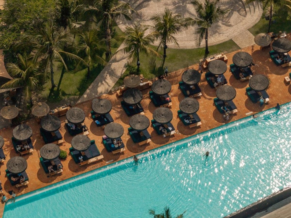 an overhead view of a swimming pool with lounge chairs and a pool at Desa Potato Head Bali in Seminyak