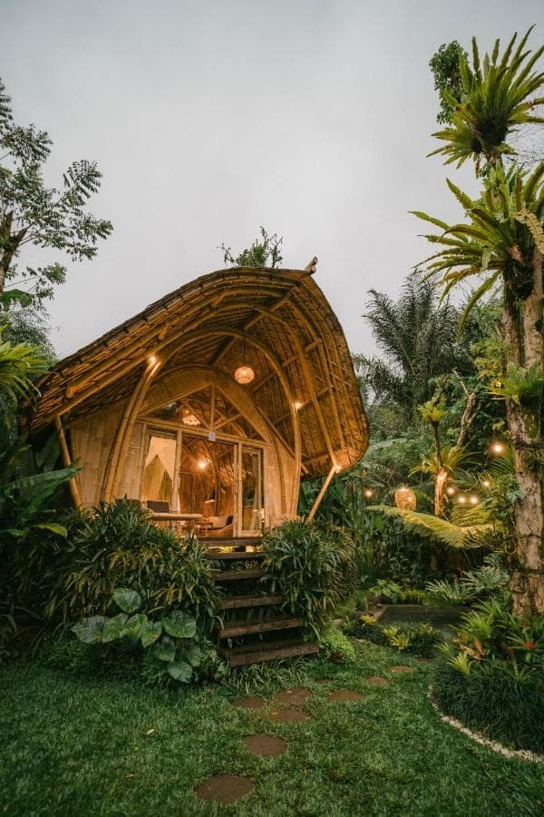 a bamboo house in the middle of a garden at Arcada Bali Bamboo House in Sidemen
