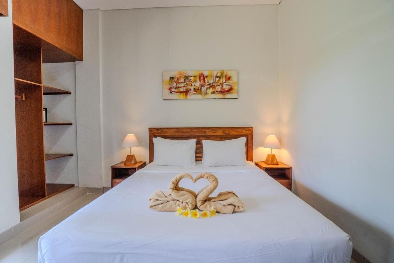 a bedroom with a bed with two swans towels at Zaara Guesthouse Uluwatu in Uluwatu