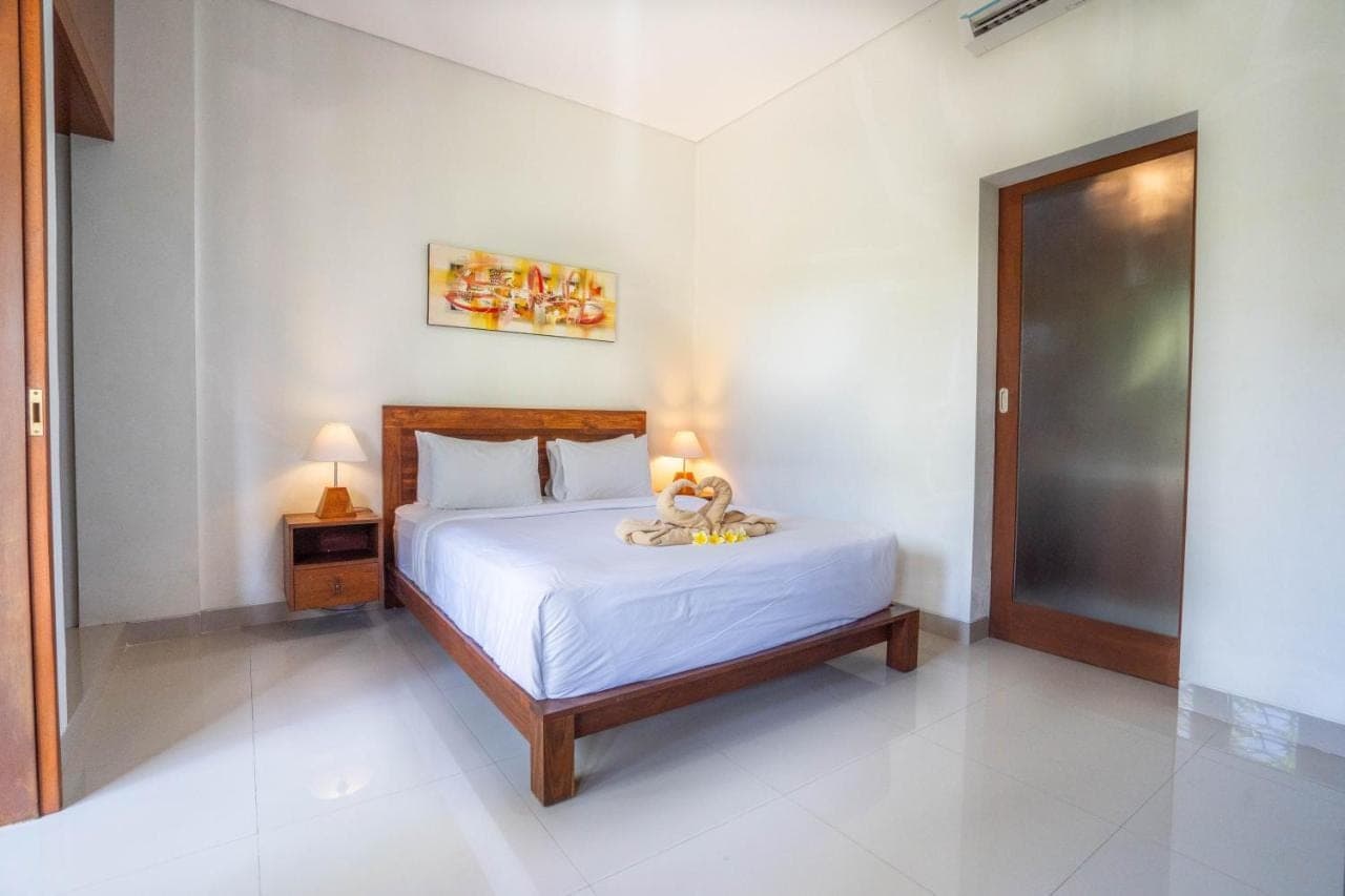 a bedroom with a bed with two lamps on it at Zaara Guesthouse Uluwatu in Uluwatu