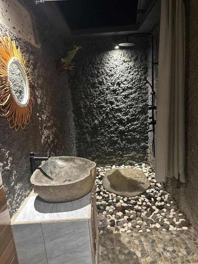 a bathroom with two sinks and a stone wall at Bien dormir house in Sidemen