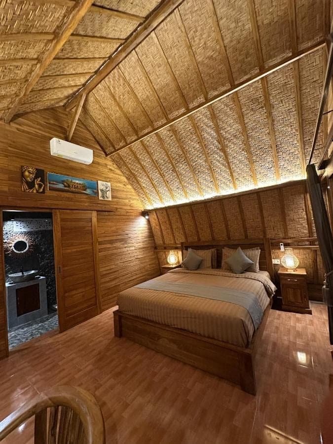a bed in a room with a wooden ceiling at Bien dormir house in Sidemen