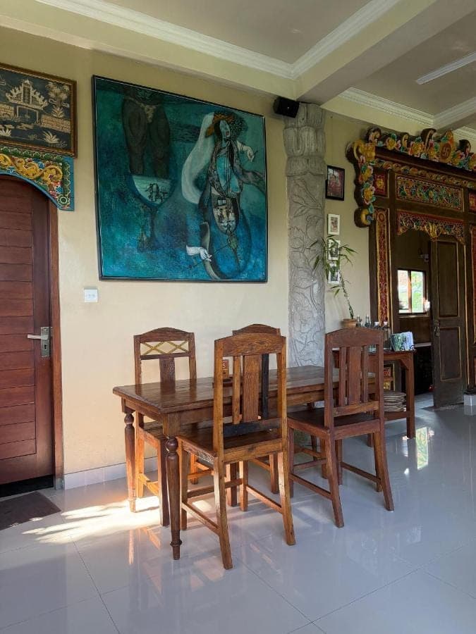 a dining room with a wooden table and two chairs at Nirwa Ubud Karma in Ubud