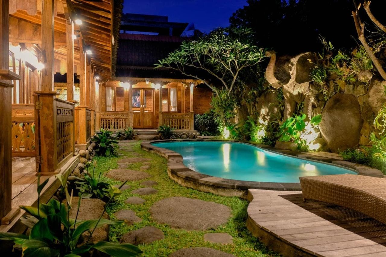 a swimming pool in the yard of a house at Pondok Kayu Batu in Ubud