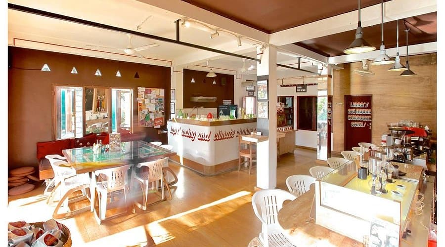The sunny room inside, with glass-topped tables and the roasting counter