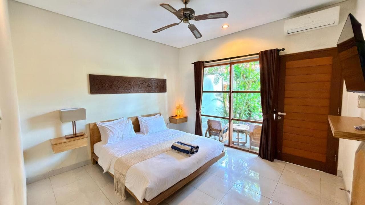 a bedroom with a bed and a window at Moonlight Sanur in Sanur