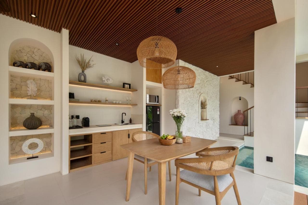 a kitchen with a wooden table and chairs at Solaya Villas Canggu in Canggu