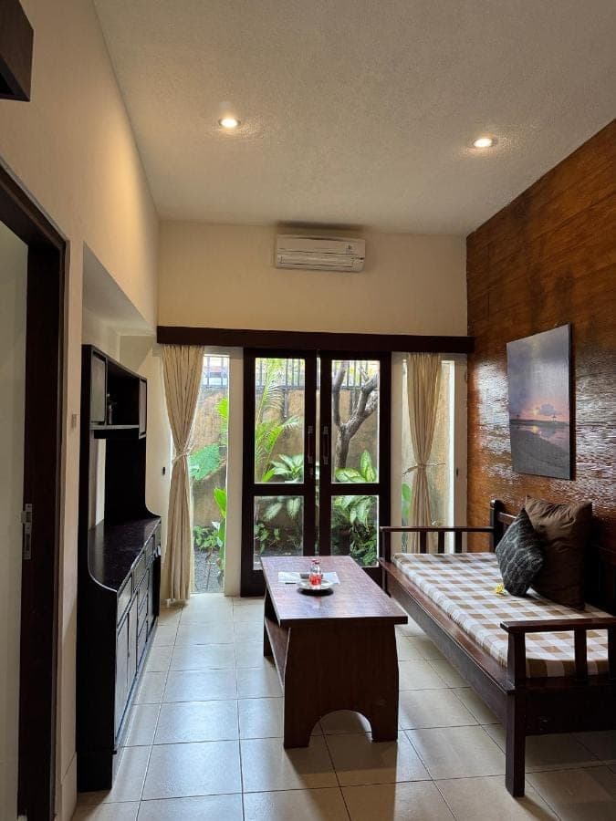 a living room with a couch and a table at Praschita Bali in Sanur