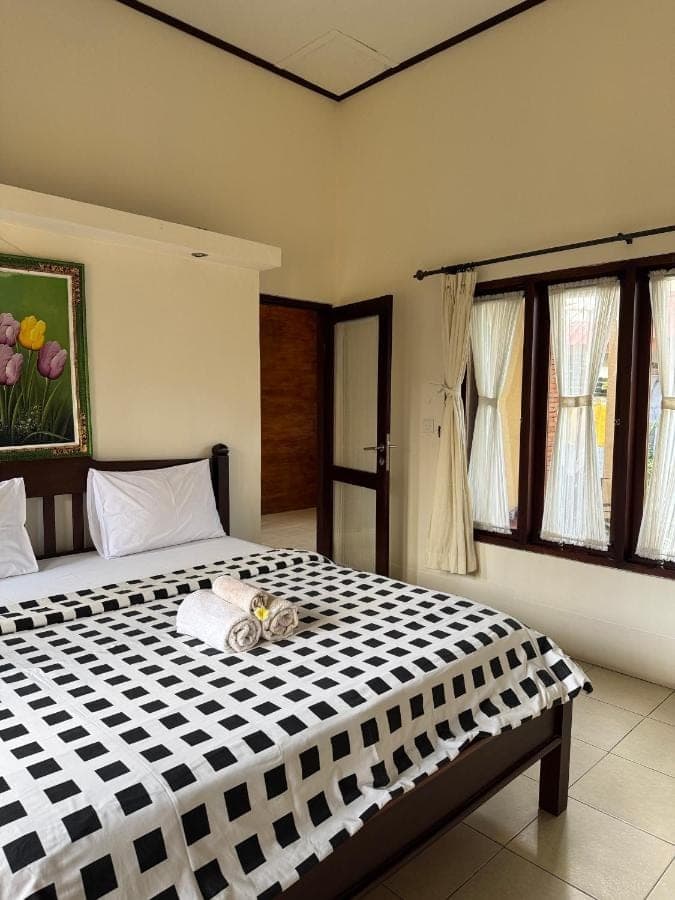 a bedroom with a bed with a cat laying on it at Praschita Bali in Sanur