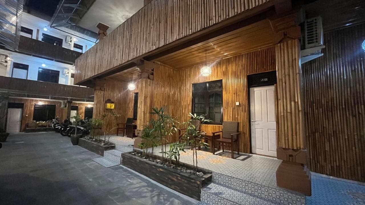 a lobby with wooden walls and a door and plants at City Garden Bali Dwipa Hotel, Kuta in Kuta