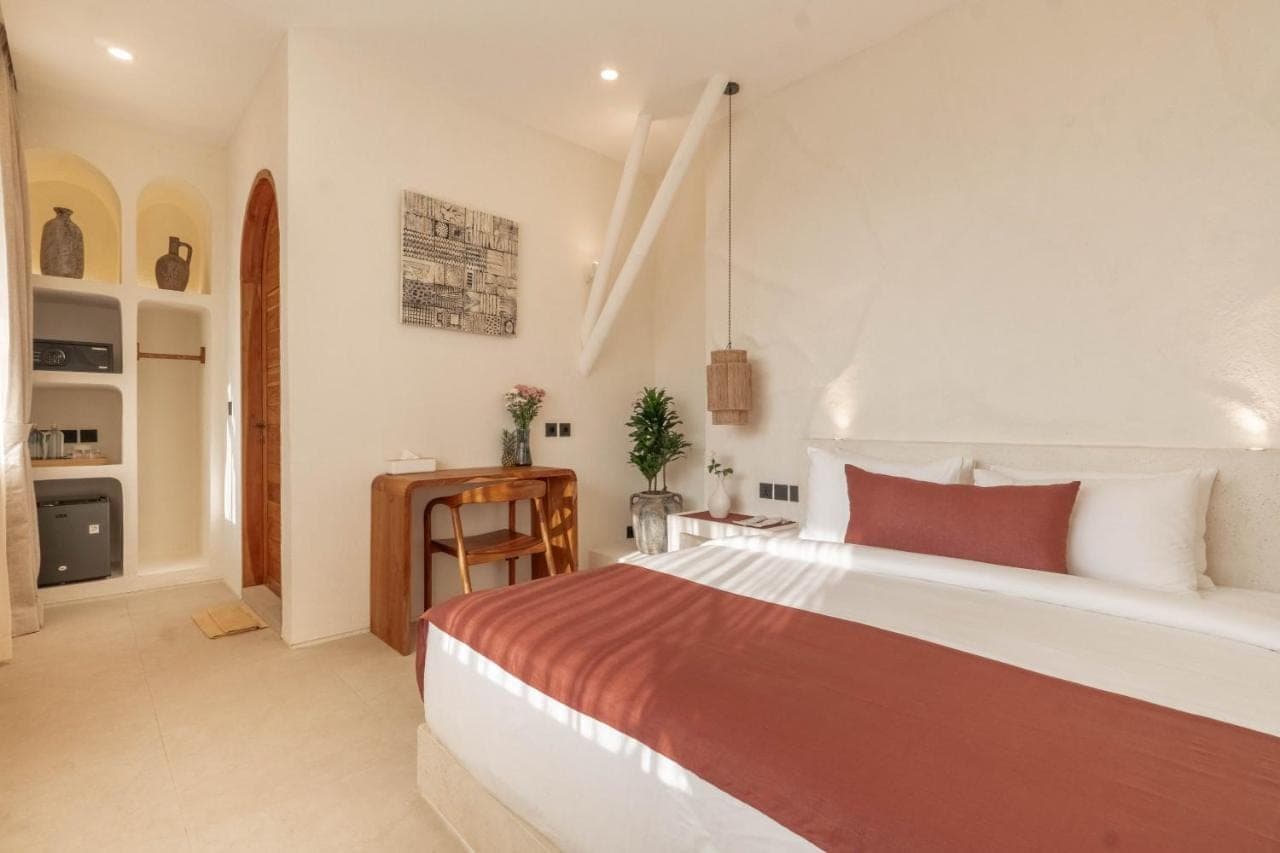 a bedroom with a large bed and a desk at AMARA Ocean Living -Uluwatu Padang Padang in Uluwatu