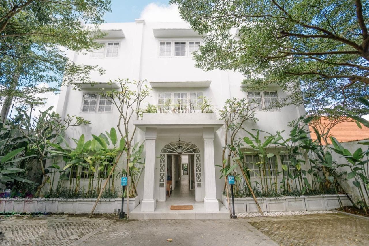 a white building with a gate in front of it at Umalas Suites in Seminyak