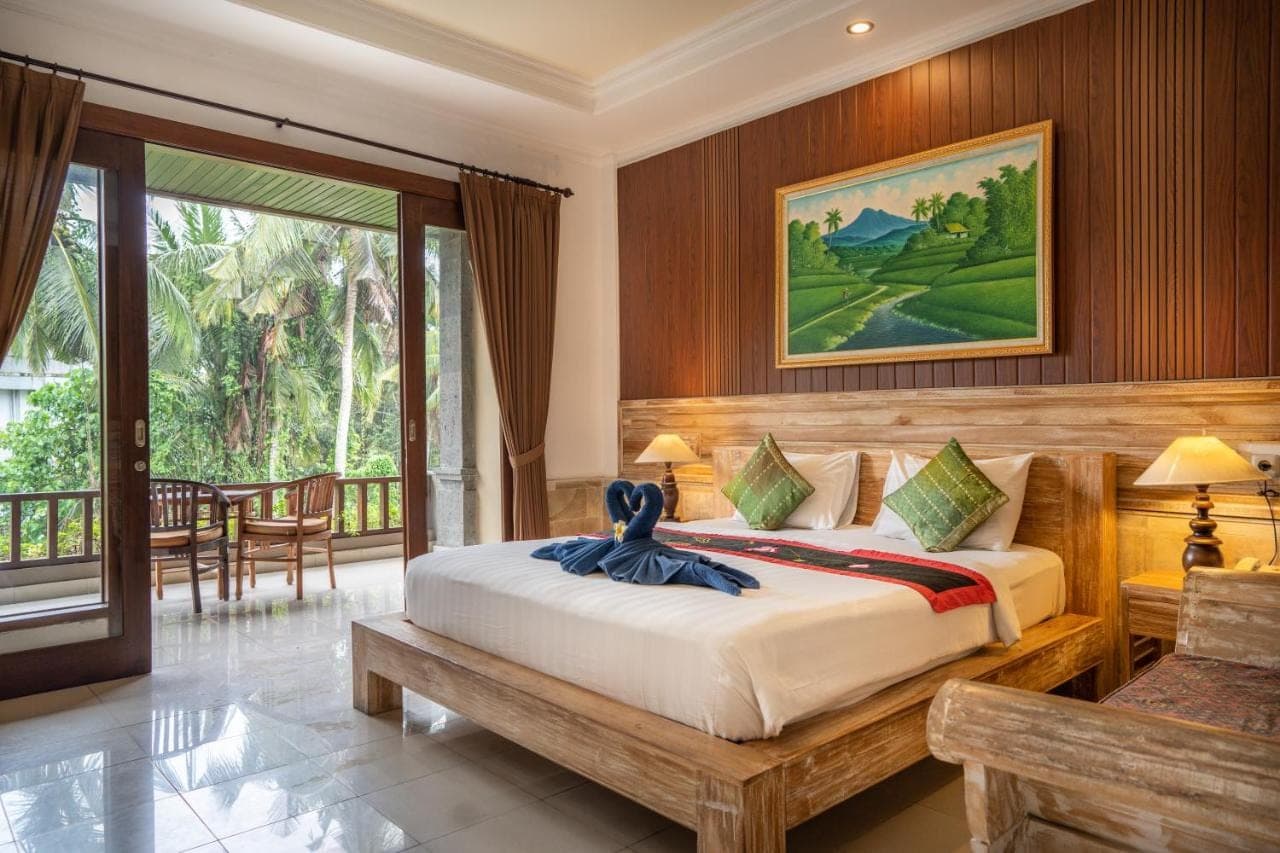 a bedroom with a bed and a balcony at Alam Terrace Cottages in Ubud