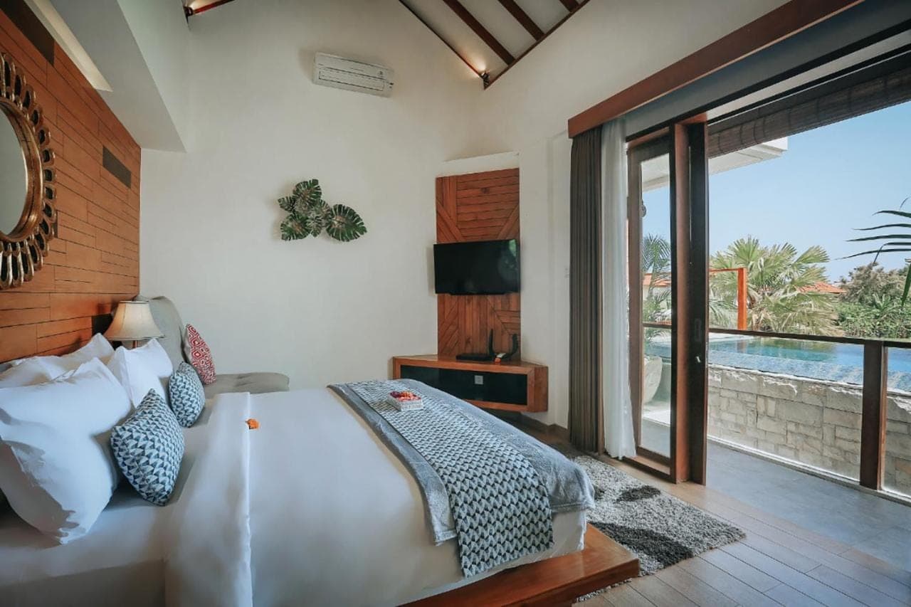 a bedroom with a bed and a large window at The Wina Villa Seminyak, Near Potato Head Beach Club in Seminyak