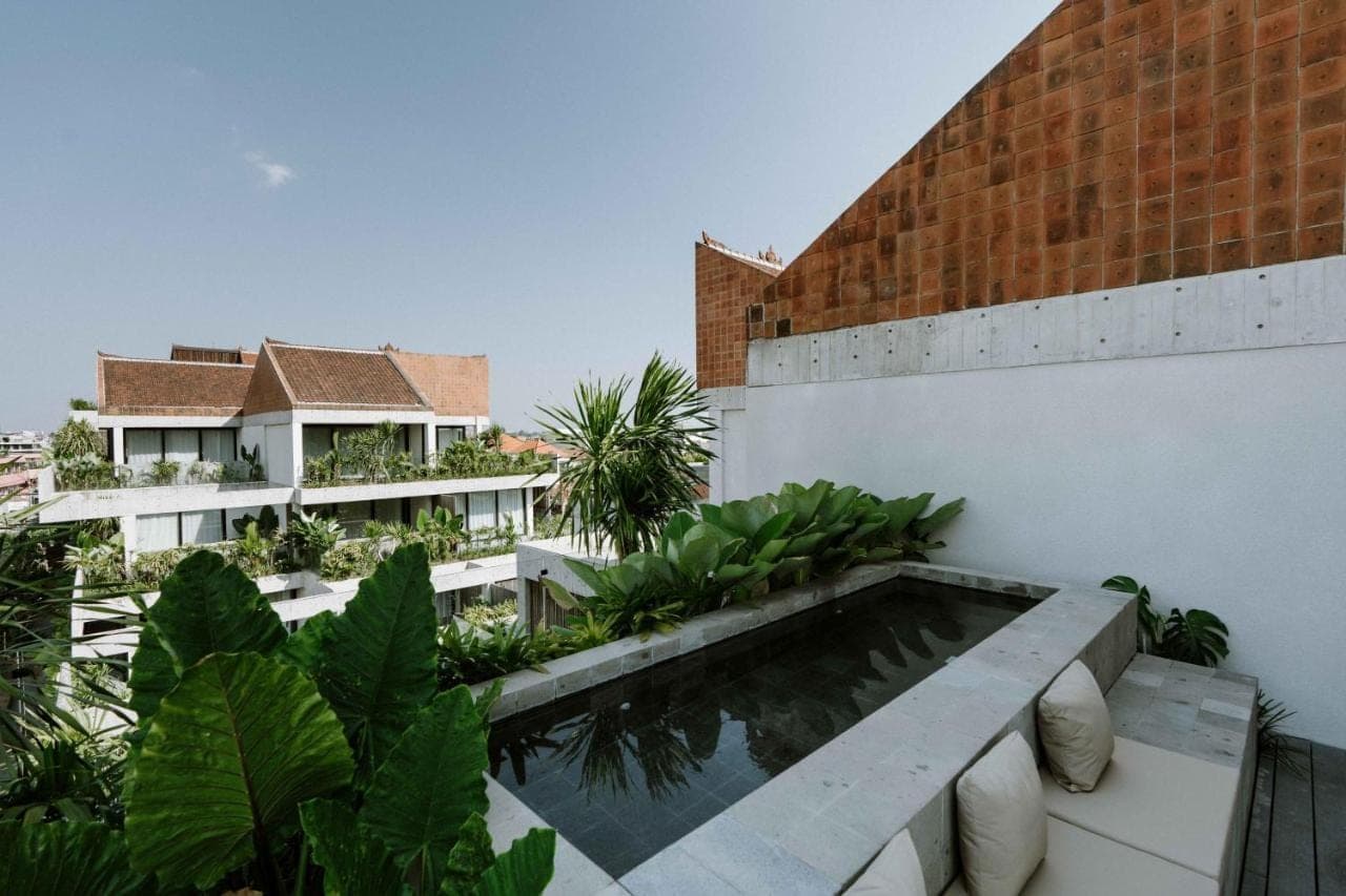 a view from the balcony of a building with a swimming pool at The Komu Canggu Bali in Canggu