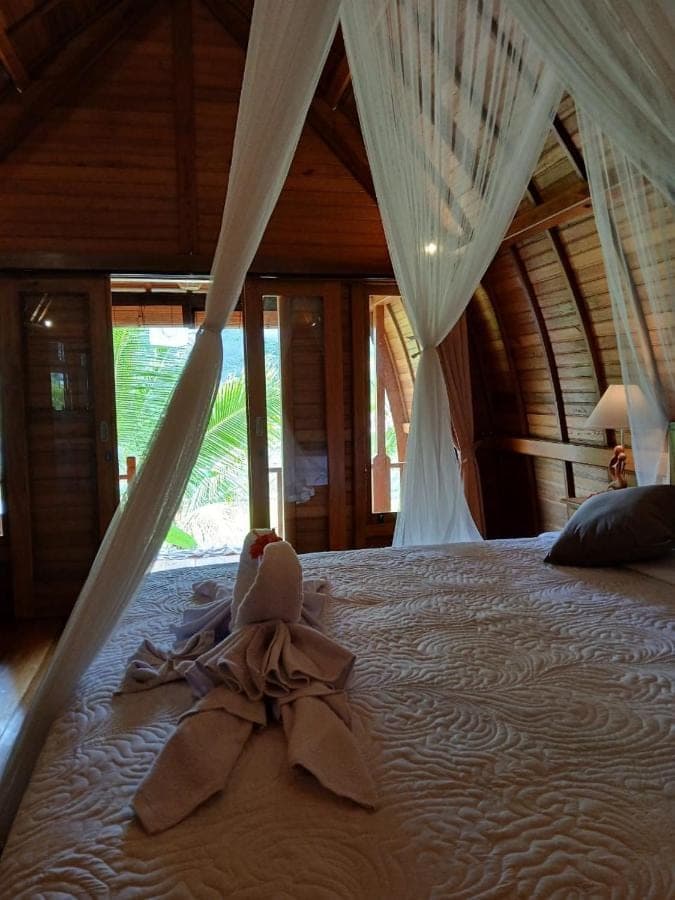 a bedroom with a bed with a baby on it at Lumbung Umaluah Villa in Sidemen