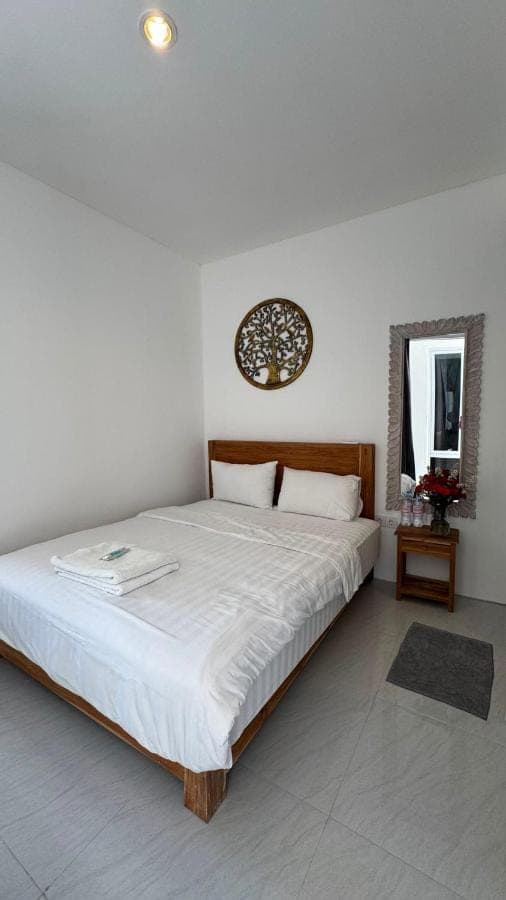 a bedroom with a large bed with white sheets at Roemah Mawar in Sanur