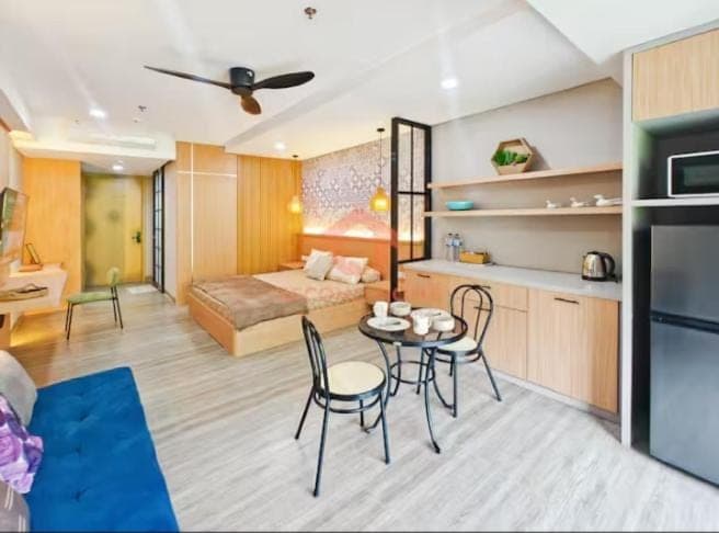 a living room with a bed and a table and chairs at Lavaya Resort 1BR Nusa Dua Pool, WiFi, Netflix in Nusa Dua