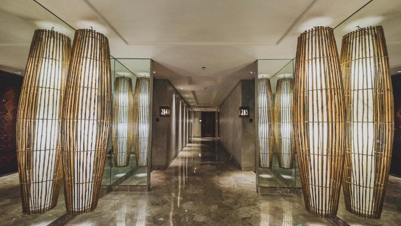 a hallway in a building with glass columns at Amnaya Resort Nusa Dua in Nusa Dua