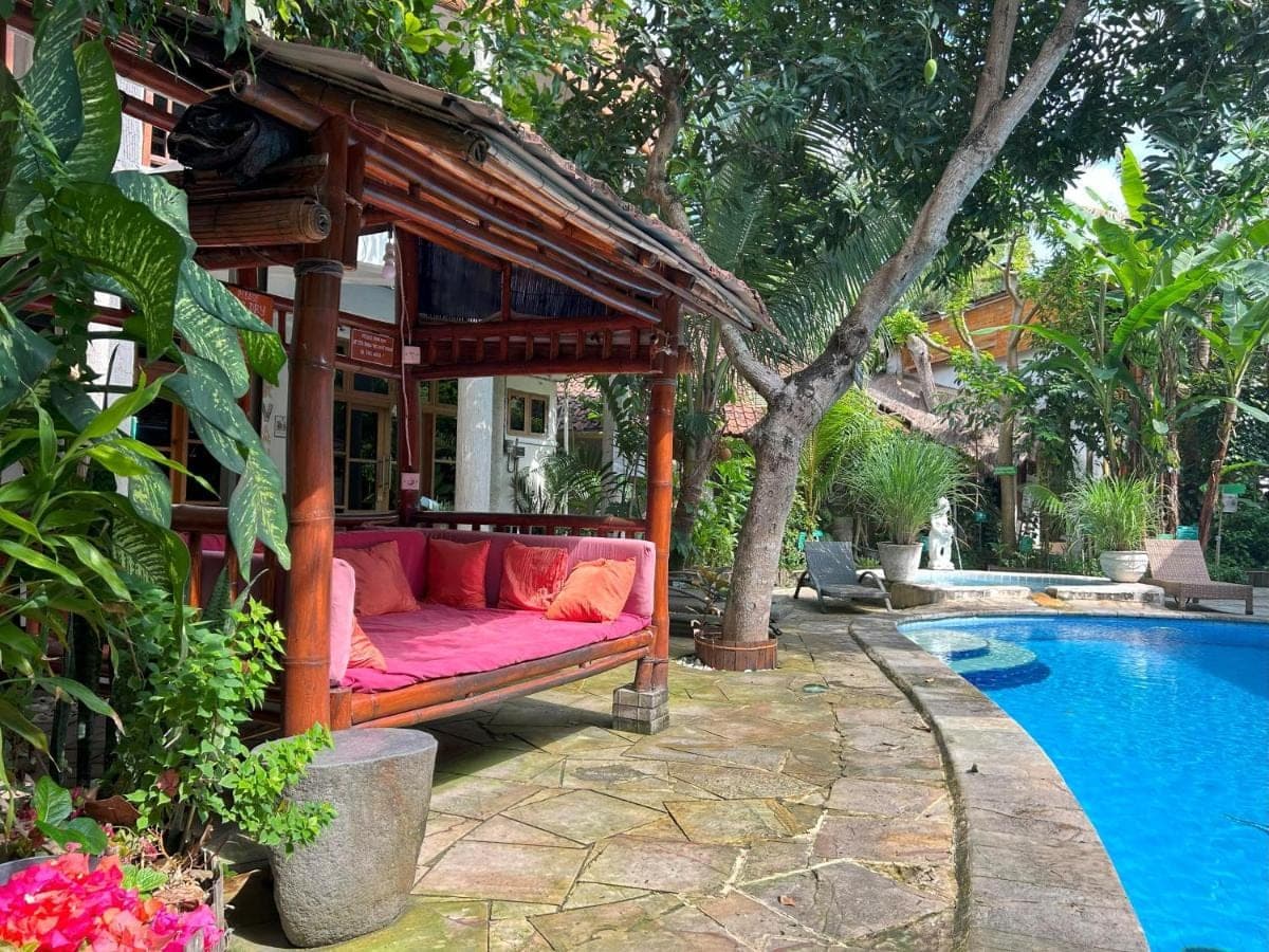 a couch in a gazebo next to a pool at Serenity Eco Guesthouse and Yoga- CHSE certified in Canggu