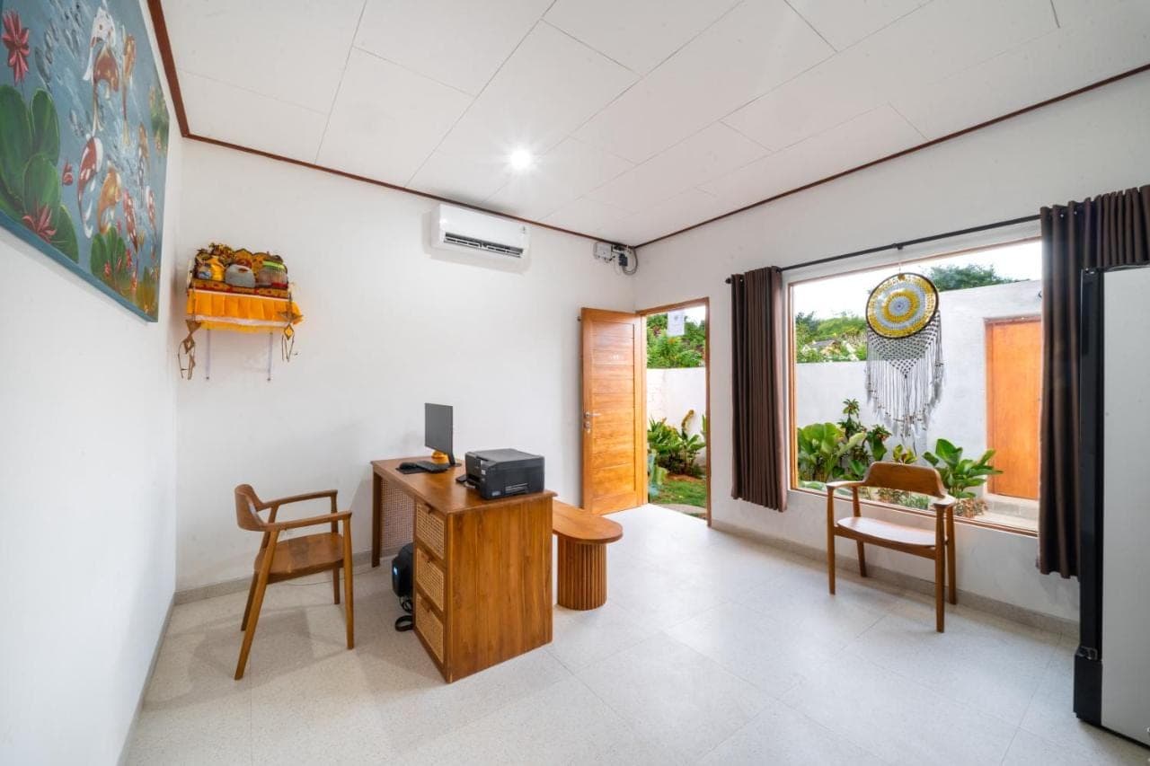 a room with a desk and chairs and a window at Wodis Uluwatu in Uluwatu