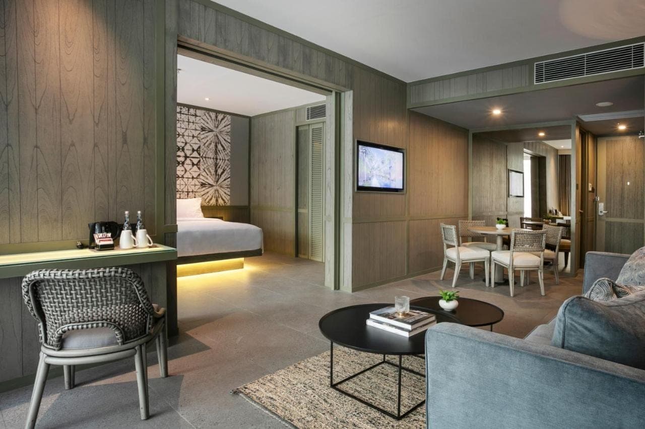 a hotel room with a bed and a living room at Kanvaz Village Resort Seminyak in Seminyak