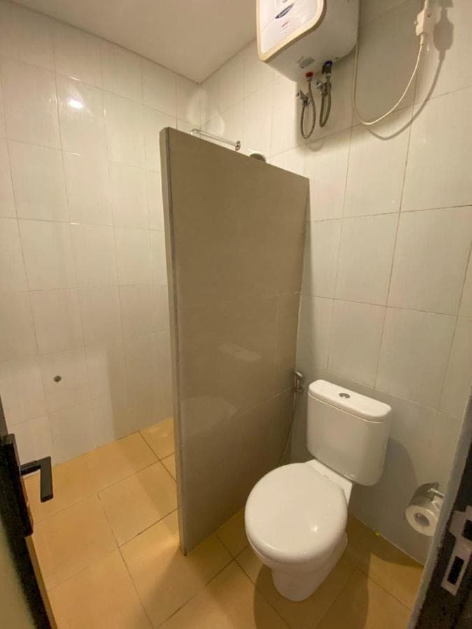 a bathroom with a toilet and a shower stall at Malaka pedati homestay in Uluwatu