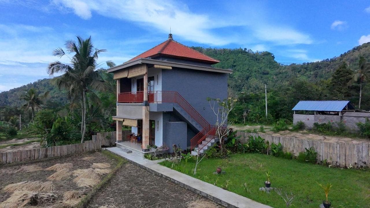 a house with a red roof and a fence at Tirta Unda Sidemen in Sidemen