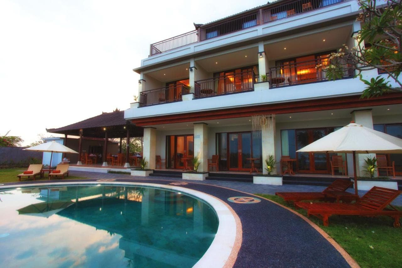 a hotel with a swimming pool in front of a building at Puri Pandawa Resort in Nusa Dua
