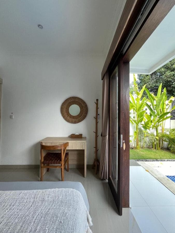 a bedroom with a bed and a desk and a table at Villa Kelle - Uluwatu Nusa Dua in Nusa Dua