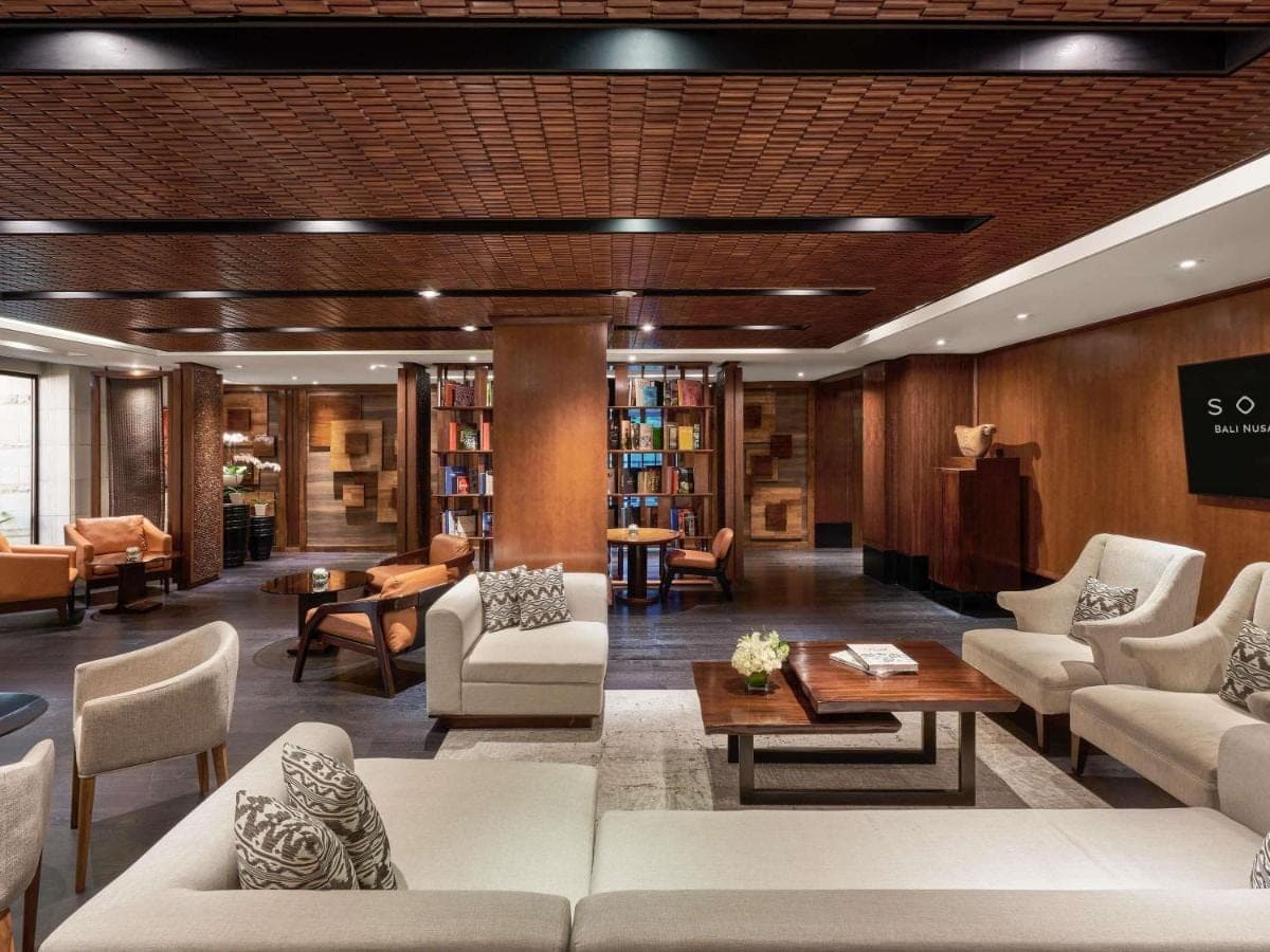 a library with white couches and chairs and books at Sofitel Bali Nusa Dua Beach Resort in Nusa Dua
